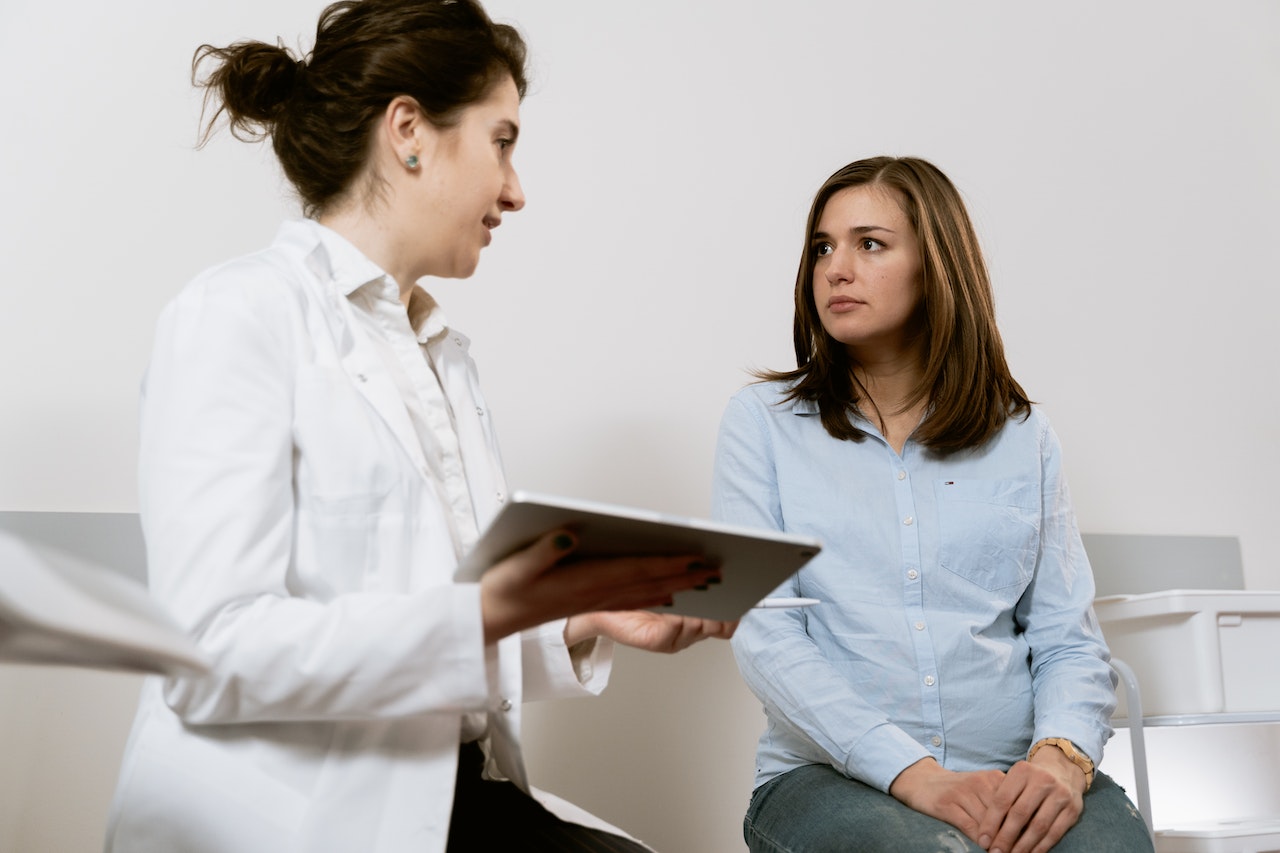 Kobieta przed zabiegiem lipofilingu rozmawia z lekarzem